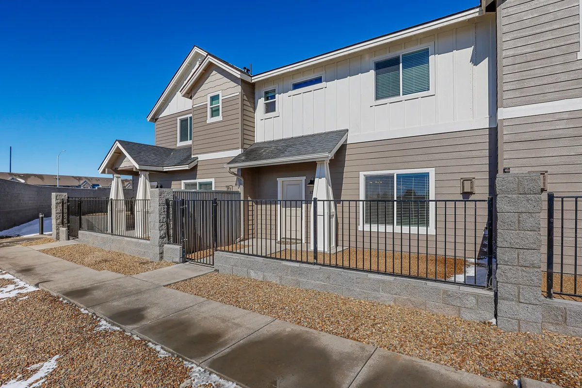 This image showcases the front entrance of the home, complete with a fenced area and inviting landscaping. The porch offers a comfortable space for relaxation or gatherings, while the overall scene conveys a welcoming gateway to adventure.
